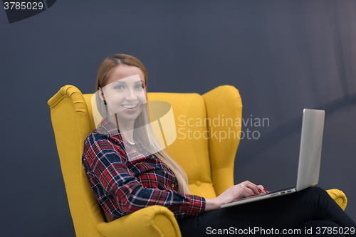 Image of startup business, woman  working on laptop and sitting on yellow