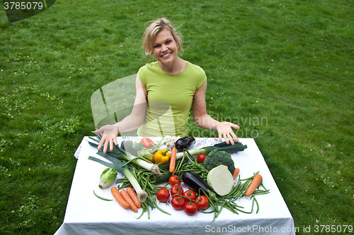 Image of Cute blond girl with vegetables