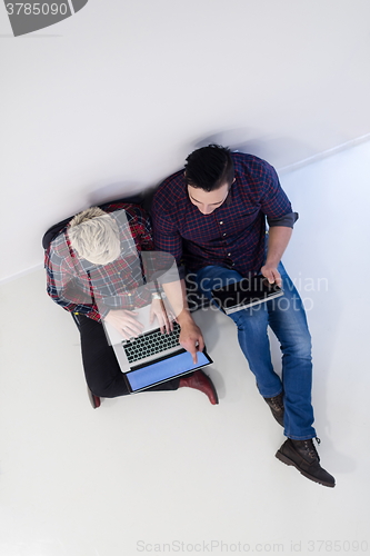 Image of top view of  couple working on laptop computer at startup office