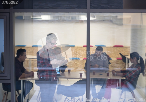 Image of business woman in meeting room  speaking by cell phone