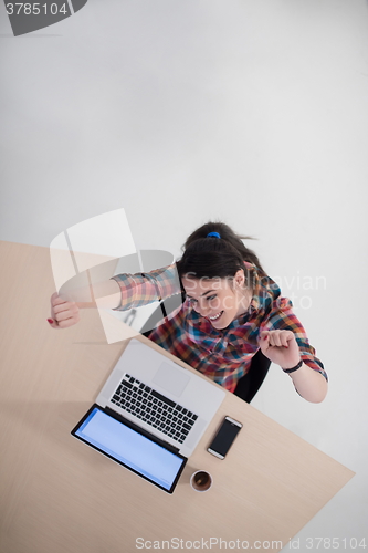 Image of top view of young business woman working on laptop