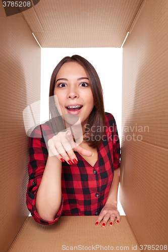 Image of Girl opening a carton box and looking inside