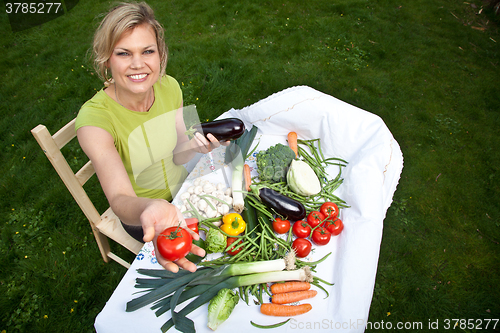 Image of Cute blond girl with vegetables