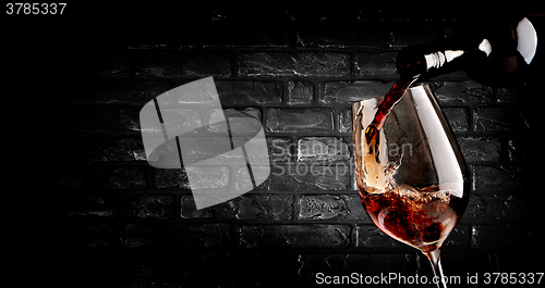 Image of Pouring wine and brick wall
