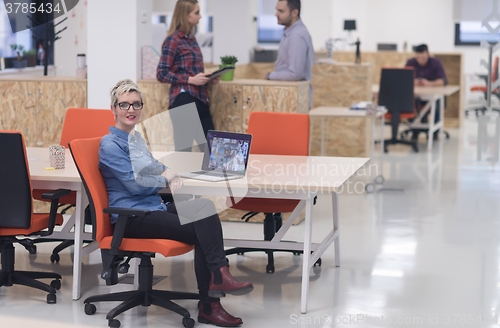 Image of portrait of young business woman at office with team in backgrou