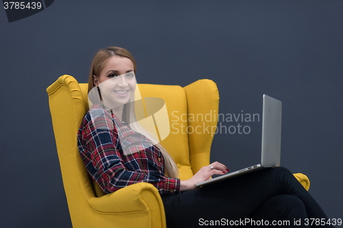 Image of startup business, woman  working on laptop and sitting on yellow