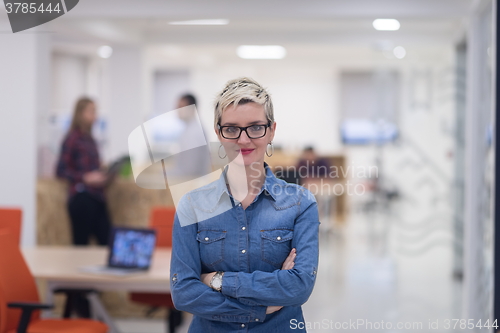 Image of portrait of young business woman at office with team in backgrou