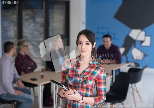 Image of portrait of young business woman at office with team in backgrou