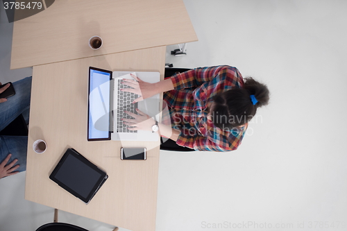 Image of top view of young business woman working on laptop
