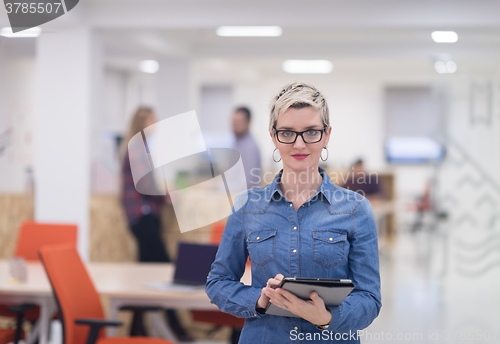 Image of portrait of young business woman at office with team in backgrou