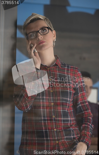 Image of business woman in meeting room  speaking by cell phone