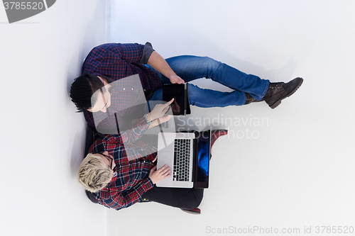Image of top view of  couple working on laptop computer at startup office