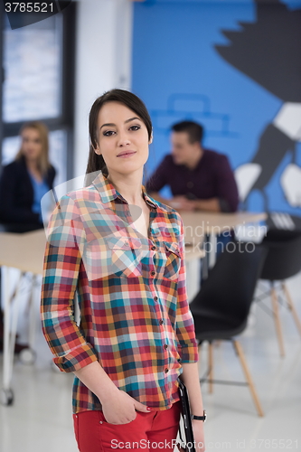 Image of portrait of young business woman at office with team in backgrou