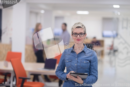 Image of portrait of young business woman at office with team in backgrou