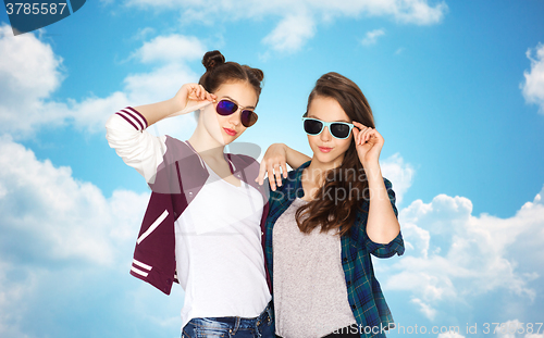 Image of happy teenage girls in sunglasses over blue sky
