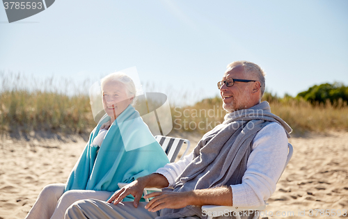 Image of happy senior couple in chairs on summer beach