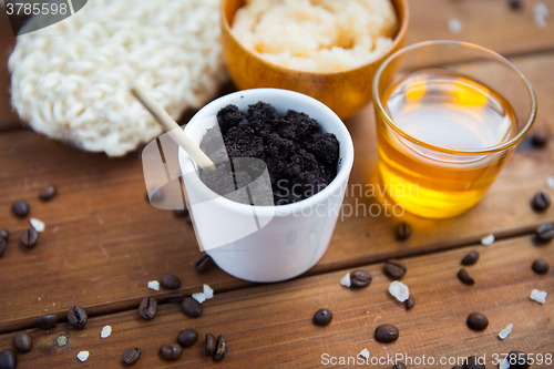 Image of close up of coffee scrub in cup and honey on wood