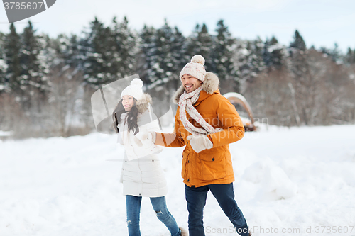 Image of happy couple running over winter background