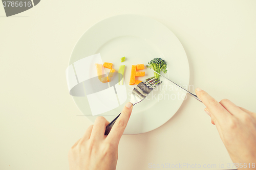 Image of close up of woman hands eating vegetables