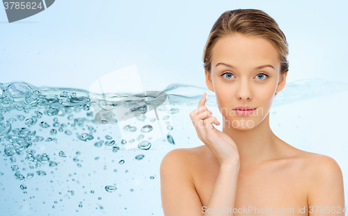 Image of young woman applying cream to her face