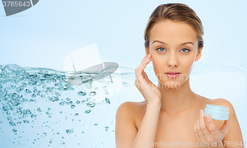 Image of young woman applying cream to her face