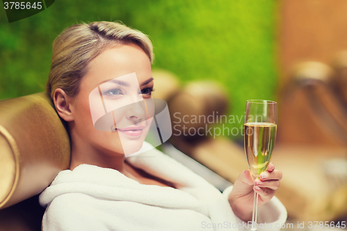 Image of beautiful young woman drinking champagne at spa