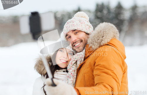 Image of happy couple taking selfie by smartphone in winter