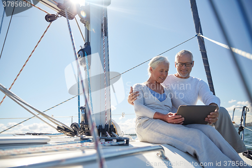 Image of senior couple with tablet pc on sail boat or yacht