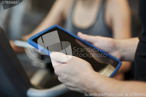 Image of close up of trainer hands with tablet pc in gym