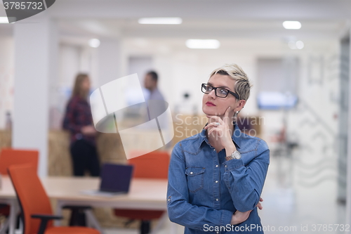 Image of portrait of young business woman at office with team in backgrou