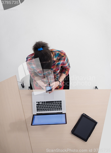 Image of top view of young business woman working on laptop