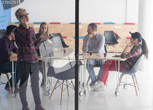 Image of business woman in meeting room  speaking by cell phone