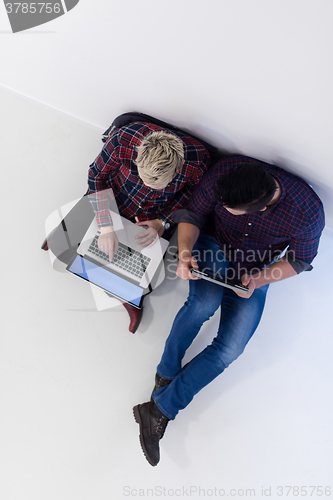 Image of top view of  couple working on laptop computer at startup office