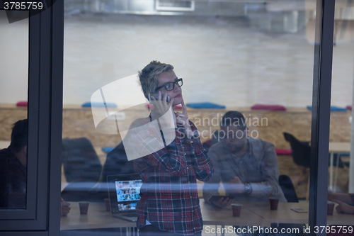 Image of business woman in meeting room  speaking by cell phone