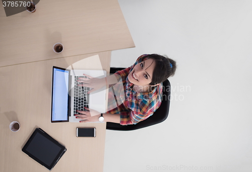 Image of top view of young business woman working on laptop