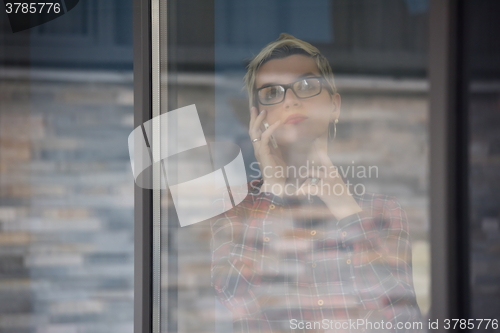 Image of business woman in meeting room  speaking by cell phone