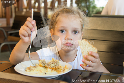 Image of Four-year girl has lunch at an outdoor cafe