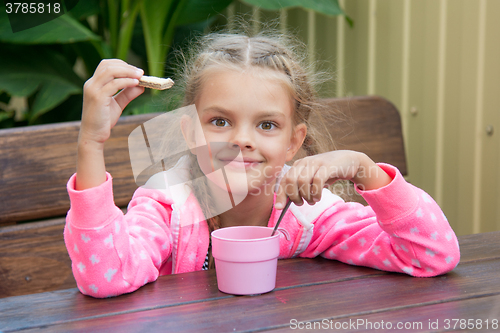 Image of Six-year girl has breakfast on the veranda