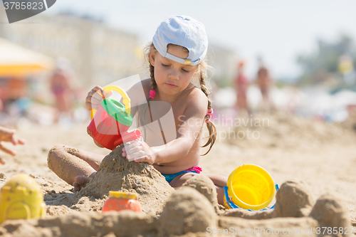 Image of Four-year girl playing in the sand on beach seaside