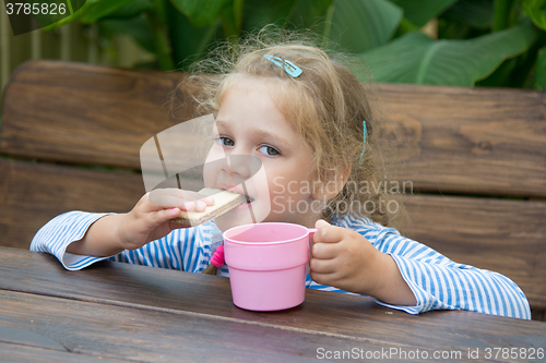 Image of Four-year girl waffle bites and drinks tea