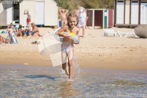 Image of Happy girl running to swim in the sea