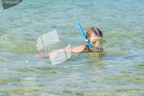 Image of Girl floats over the water with mask and snorkel