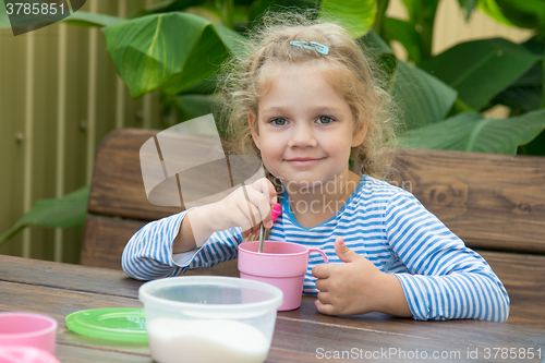 Image of The four-year girl in tea interferes with sugar for breakfast