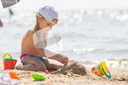 Image of The girl on the beach seaside playing in the sand