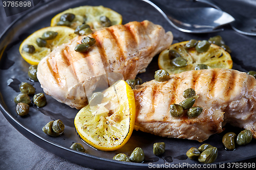 Image of grilled chicken breasts on gray plate