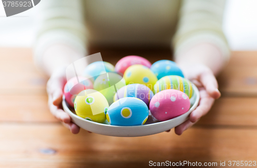 Image of close up of woman hands with colored easter eggs