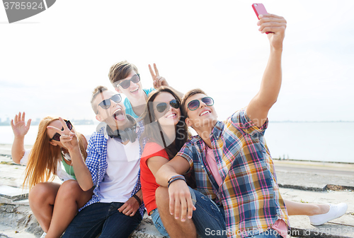 Image of happy friends with smartphone taking selfie