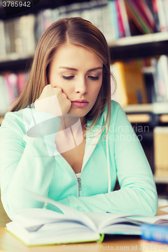 Image of student girl reading book in library