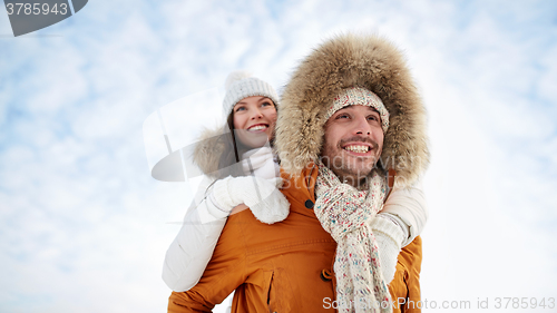 Image of happy couple having fun over winter background