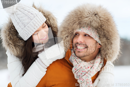 Image of happy couple having fun over winter background